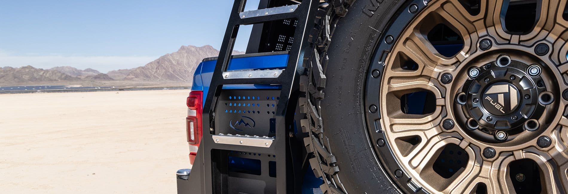 Bronze wheel on blue truck in the desert