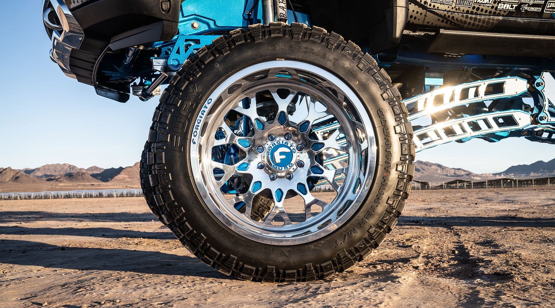 Silver wheels on silver and blue truck in the desert