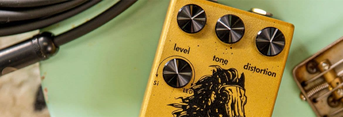Guitar pedal in yellow on green background